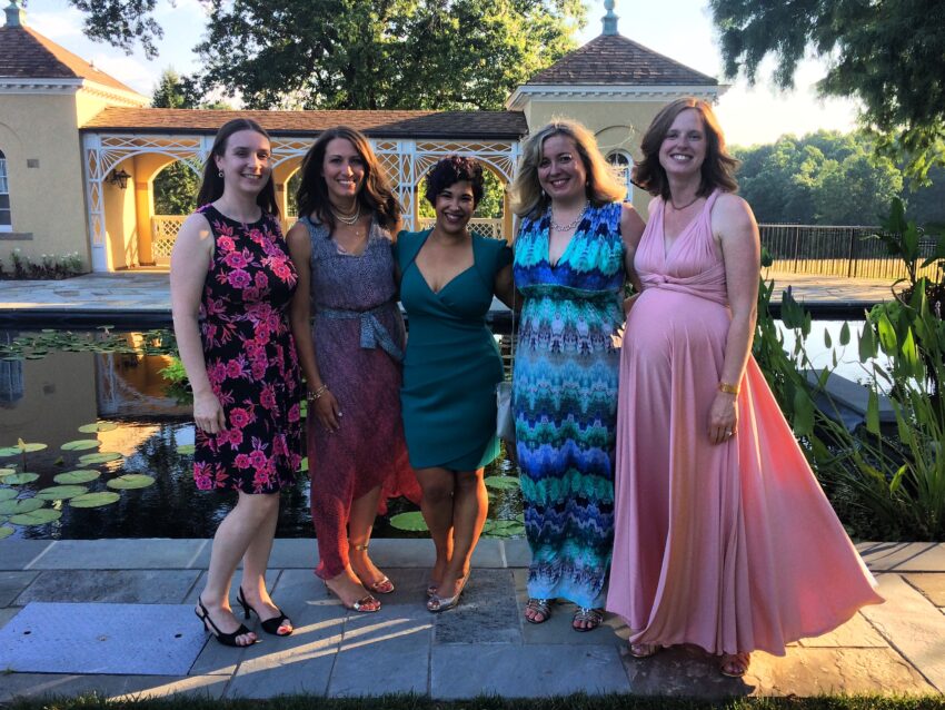 Five women standing together, dressed up for an event, with Felicia in the center